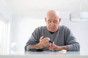 Man testing his blood sugar level, concept of diabetes monitoring and glucose management.