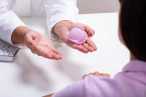 doctor showing contraception ring and diaphragm options to woman seeking birth control
